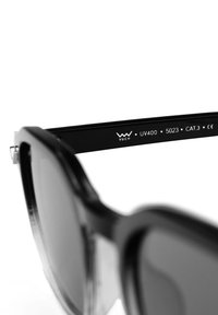 Černé sluneční brýle s velkými čočkami a texturovanými obrubami. Na stranu je umístěno logo značky "VUCH" a označení UV400. Sluneční brýle kategorie CAT. 3.