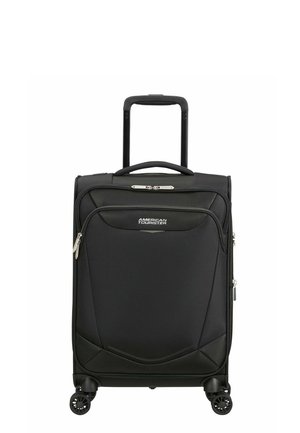 Valise cabine rigide noire American Tourister avec poignée télescopique et poche avant zippée, debout sur quatre roues pivotantes.