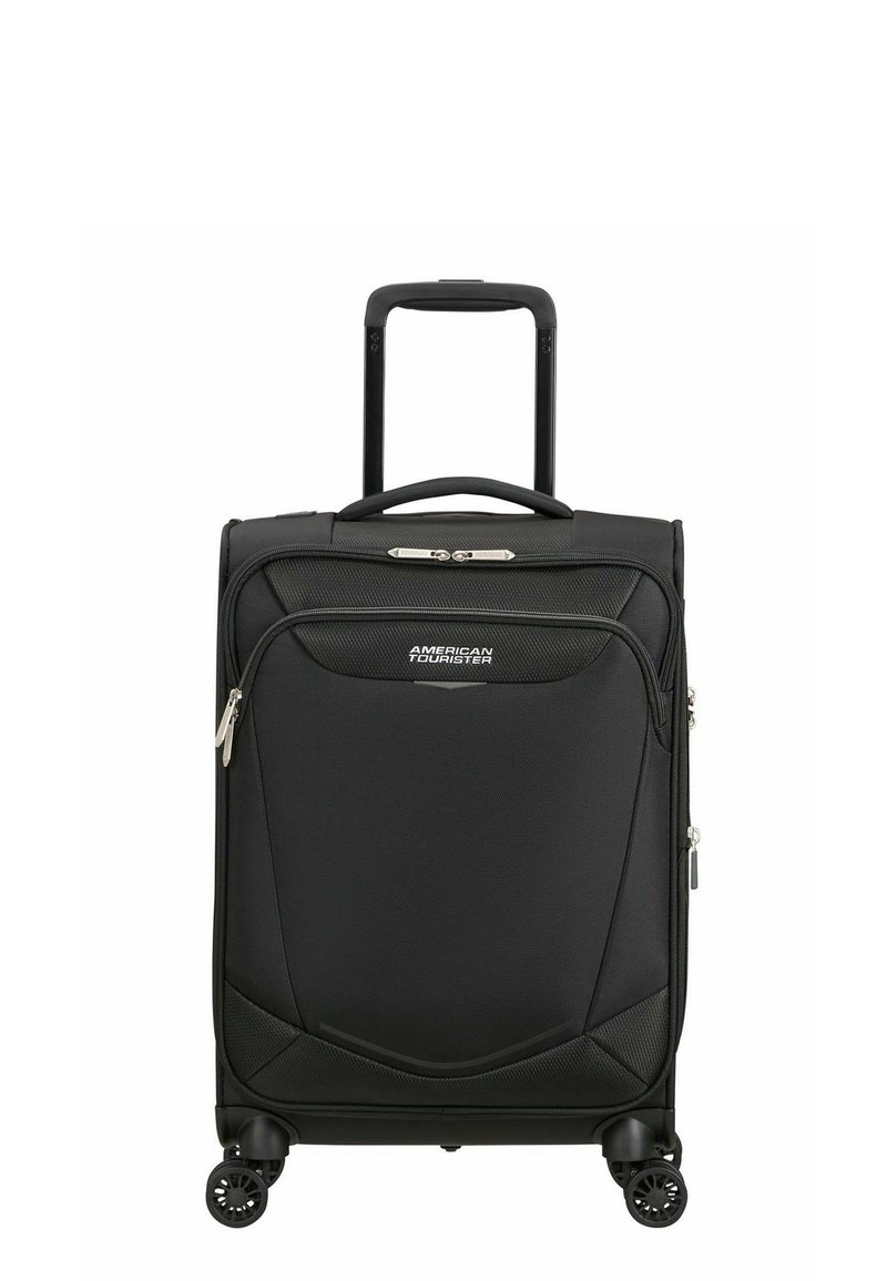 Valise cabine rigide noire American Tourister avec poignée télescopique et poche avant zippée, debout sur quatre roues pivotantes.