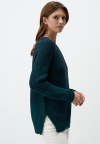 Teal gebreide trui met lange mouwen, geribbelde manchetten en zijslitsen. Heeft een gestructureerde stof en een relaxte pasvorm.