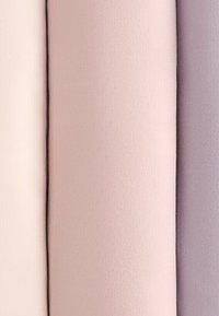 Vier rollen stof in zachte kleuren: lichtbeige, lichtroze, gedempt roze en lichtpaars, verticaal gerangschikt.