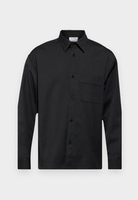 Zwarte langslijfshirt met een button-down kraag, een borstzak en een rechte zoom. Gemaakt van een gladde, gestructureerde stof.