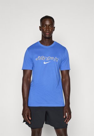 T-shirt in cotone blu con il testo "JUST DO IT" e il logo Nike bianchi. La maglietta ha maniche corte e un design classico a girocollo.
