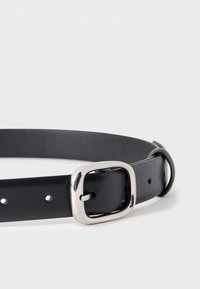 Μαύρη δερμάτινη ζώνη με ορθογώνια ασημένια μεταλλική αγκράφα, με ομοιόμορφα κατανεμημένες τρύπες και λεία υφή. Απλός και λειτουργικός σχεδιασμός.