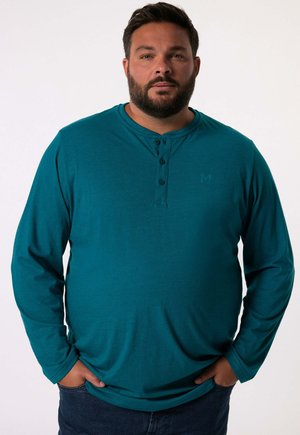 Türkisfarbenes Langarmhemd mit Henley-Ausschnitt, ausgestattet mit drei Knöpfen und einem geprägten Logo auf der Brust. Weicher, glatter Stoff.