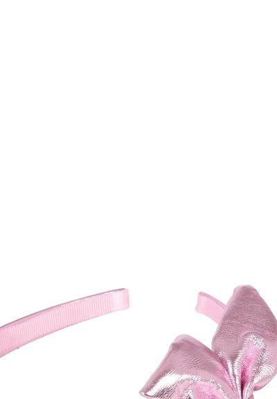 Roze metalen strik bevestigd aan een lichtroze plastic haarband tegen een witte achtergrond.