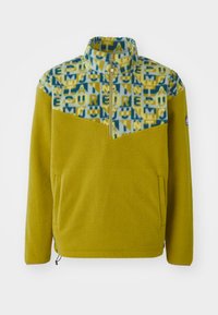Fleece-pullover i gul med mønstret blå og gul øverdel. Har halv-zip krage, sidelommer og elastisk hem-detaljering.