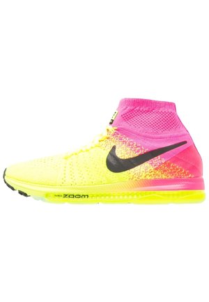 Gelber und pinker Nike Zoom Laufschuh mit schwarzem Swoosh-Logo und hohem sockenähnlichen Schaft, von der Seite gezeigt.