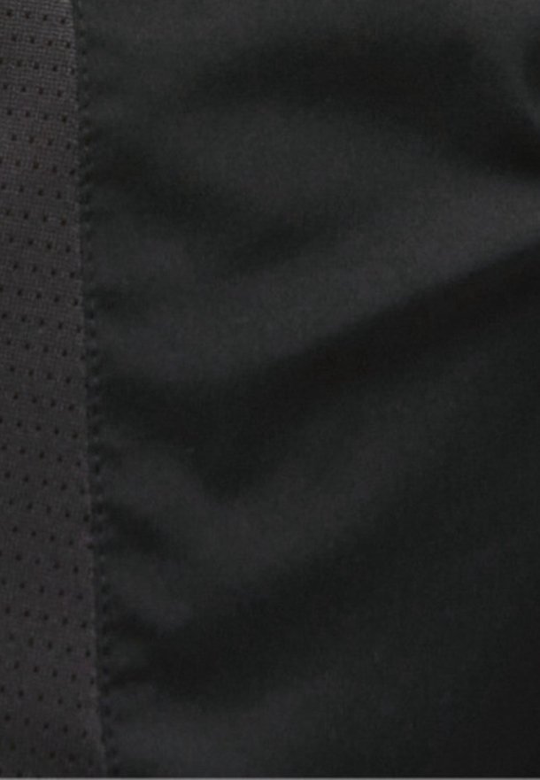 Tessuto nero con una superficie liscia e lucida, caratterizzato da una striscia testurizzata e traforata lungo un lato. L'aspetto generale è piatto e uniforme.