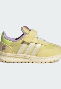 Yellow suede and fabric shoe with three white stripes, purple accents, and a hook-and-loop strap. Features a textured sole.