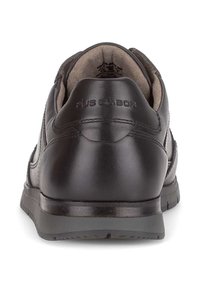 Zwarte leren schoen met een ronde hak en grijze rubberen zool. Heeft stikdetails en een geperst logo op de achterkant. Het interieur heeft een zachte voering.