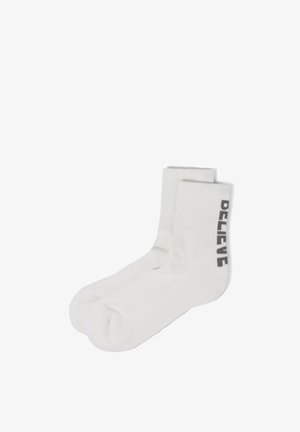 Weiße Crew-Socken mit gerippten Bündchen und dem Wort „DELIVE“ vertikal in Schwarz an der Seite gedruckt.