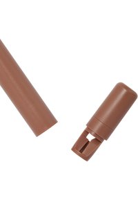 Brun plastikkube og lokk med en glatt tekstur; lokket har en spaltet åpning for bruk med tuben.