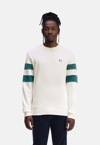 Sudadera crema con rayas verdes en las mangas, cuello y puños acanalados, con un pequeño logo bordado en el pecho.