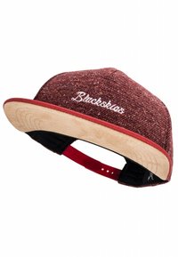 Red and beige cap with a textured fabric crown and a suede visor, featuring white embroidered text on the front and an adjustable strap.