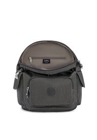 Sac à dos gris texturé de forme arrondie, avec un dessus zippé, une poche avant et une doublure intérieure. Logo de la marque visible à l'avant.