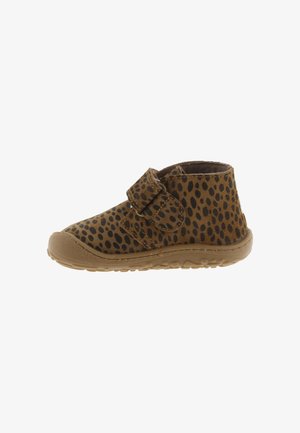 Scarpa marrone per bambino con macchie nere, suola in gomma e una singola chiusura in Velcro su sfondo bianco.