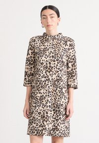 Leopardprint jurk met een hoge kraag, driekwart mouwen en zijzakken, gemaakt van een zachte, gestructureerde stof in beige en bruine tinten.