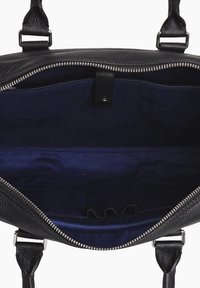 Interior de bolsa de cuero negro con forro azul marino, zipper plateado y bolsillos organizadores. Presenta una superficie texturizada y correa ajustable.