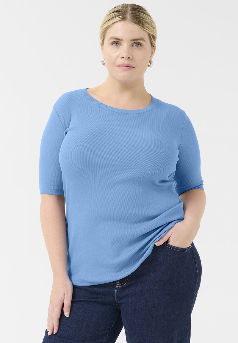 Camiseta de rayas azul claro con mangas cortas y escote redondo, combinada con jeans oscuros. Textura suave, diseño ajustado.