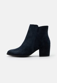Stivaletti in suede blu navale con punta affusolata e tacco a blocco. Presentano una texture liscia e dettagli di cucitura laterale. Suola in gomma piatta.