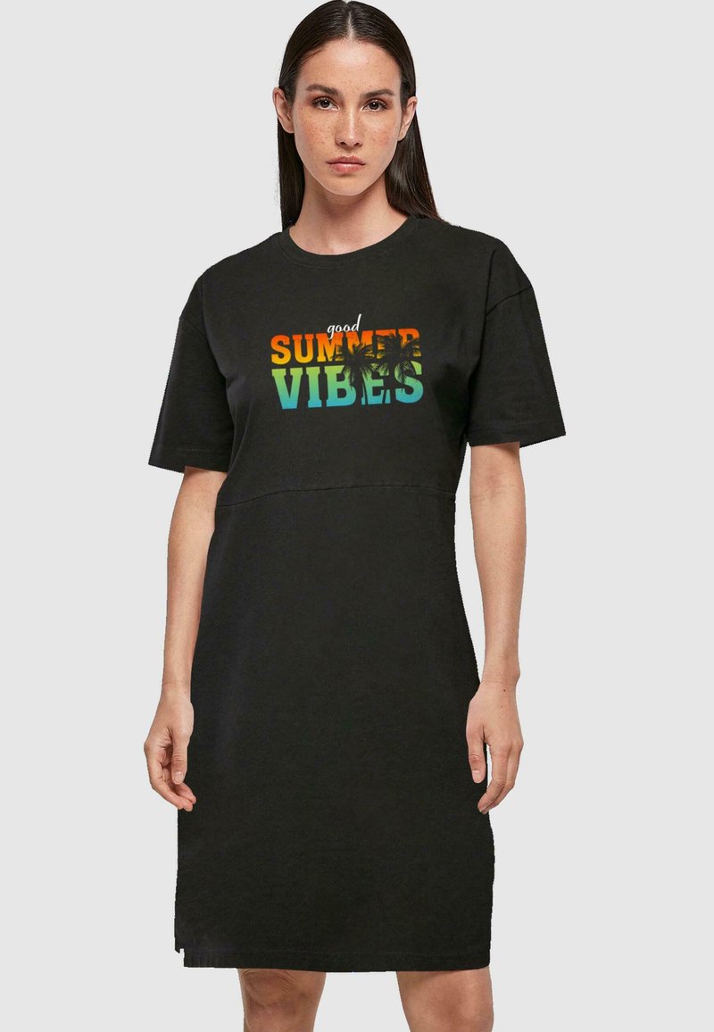 Svart t-shirtklänning med korta ärmar, rundad halsringning och tryckt text "bra sommarvibbar" i orange, grönt och blått med palmer som accent.