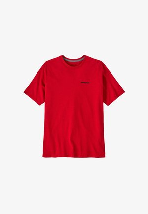 Camiseta roja de manga corta y cuello redondo con un pequeño logo negro de Patagonia impreso en el lado izquierdo del pecho, presentado sobre un fondo blanco.