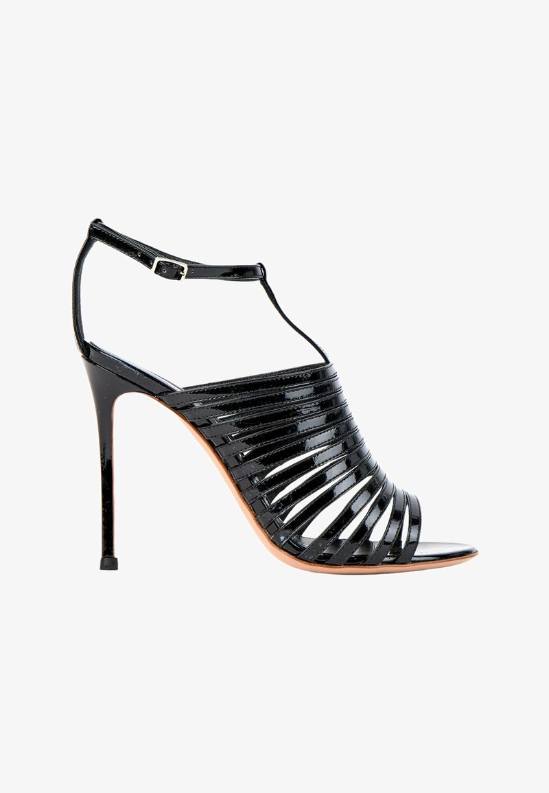 Sandale noire à talons hauts avec plusieurs fines brides, bout ouvert et bride à boucle à la cheville sur fond blanc.