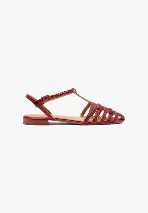 Sandal in pelle intrecciata rossa con design open toe, suola piatta e cinturino alla caviglia regolabile con chiusura a fibbia.