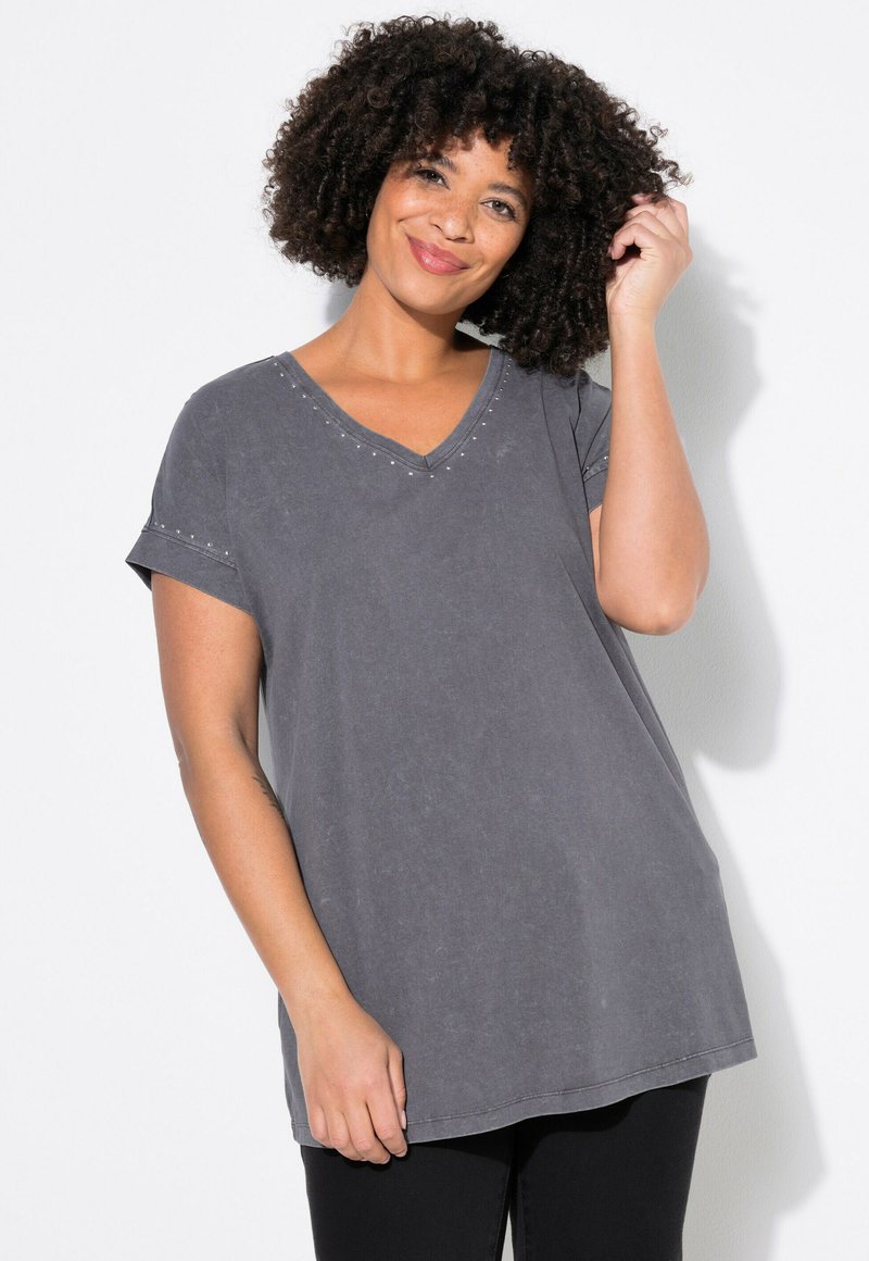 Grå V-hals t-shirt med korte ærmer, prydet med nitter langs halsudskæringen og ærmerne, lavet af blødt, struktureret stof og med en let løstsiddende pasform.