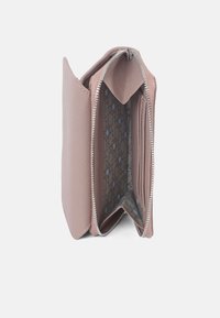 Roze leren portemonnee met een ritsluiting, voorzien van meerdere kaartsleuven en een gevoerde stof in een patroon met blauwe accenten.