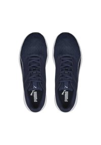 Zapatillas deportivas de color azul marino con parte superior de malla, puntera redondeada, suela blanca plana y cierre de cordones texturizado. Logo de Puma en la lengüeta.