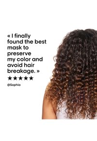 Capelli ricci con ombré marrone visibile da dietro, insieme a un testo che loda una maschera per capelli per preservare il colore e prevenire la rottura, con una valutazione a cinque stelle.