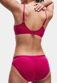 Set di bikini fucsia con spalline regolabili. Il reggiseno presenta una chiusura con gancio e un design senza cuciture, abbinato a pantaloni alti. Texture liscia.