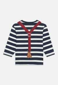 Gestreiftes Langarmshirt in Marineblau und Weiß mit einem roten Hosenträgerdesign auf dem Rücken, ausgestattet mit braunen Riemenenden und silbernen Schnallen-Details.