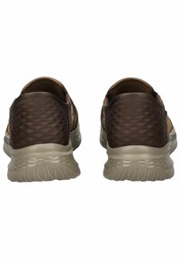 Braune Slipper aus Textiloberfläche mit einem Wabenmuster und einer hellgrauen Gummisohle. Keine sichtbaren Beschläge oder Akzente.