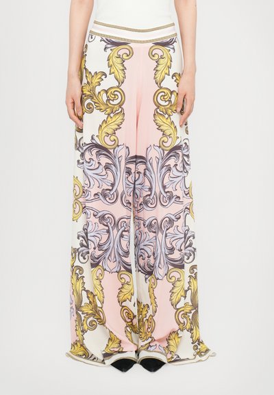 Pantalons à jambes larges avec un fond rose orné de motifs floraux et de scrolls complexes en jaune et lavande. Finition avec une taille accentuée en or.