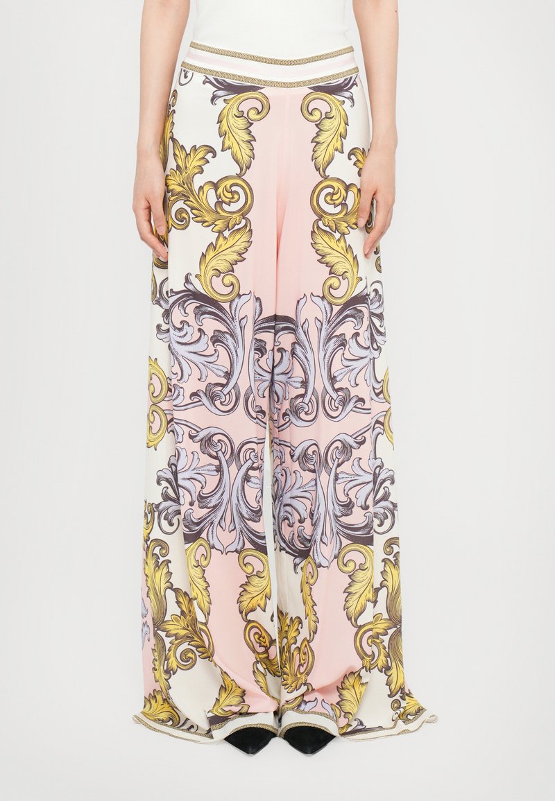 Pantaloni cu picioare largi, având un fundal roz cu modele florale și spirale complicate în galben și lavandă. Finalizați cu un tiv la talie accentuat cu aur.