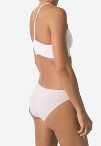 Witte bralette en bijpassende slipjes. Zacht, glad materiaal, minimalistisch ontwerp met dunne bandjes en een delicate afwerking op de tailleband.