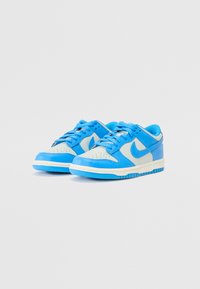 Blaue Nike-Sneaker mit einem glatten Lederobermaterial, durchgehend perforierter Zehenpartie und kontrastierenden cremefarbenen Akzenten. Sie verfügen über blaue Schnürsenkel und eine strukturierte Sohle.