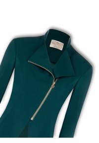 Teal fitted jasje met een gelogen kraag, asymmetrische ritsluiting met gouden hardware en een gladde, gestructureerde stof. Etiket zichtbaar.