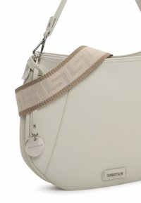 Light beige shoulder bag made of textured leather, featuring a patterned fabric strap and a metal logo tag. Curved design with zipper detail.