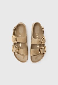 Ταμπά σανδάλια με δύο λουριά και χρυσά αγκράφες, κατασκευασμένα από λείο υλικό, με μαλακό πέλμα και υφή στη σόλα. Μέγεθος 38 σημειωμένο στο εσωτερικό.