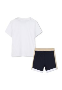 Hvit kortermet T-skjorte kombinert med marineblå shorts med en beige midje og hvit kant nederst.