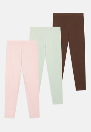 Drei Paar schlichte Leggings in Pastellrosa, Hellgrün und Dunkelbraun, überlappend auf weißem Hintergrund angeordnet.
