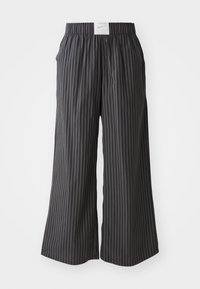 Pantalones de pierna ancha a rayas negras y grises con una cinturilla elástica y una etiqueta con el logo de Nike en la parte trasera. Tela ligera, diseño de ajuste holgado.