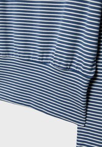 Nærbillede af marineblåt og hvidt horisontalt stribet stof med et afsnit af overlappende, foldet materiale.