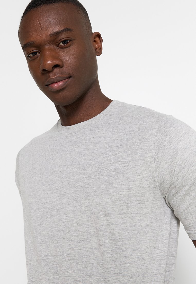 Camiseta gris de manga corta con cuello redondo, hecha de una suave tela texturizada con un sutil patrón jaspeado.