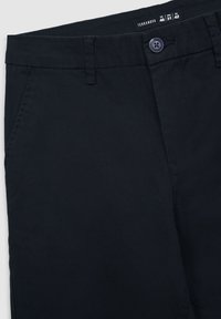 Granatowe bawełniane chinosy z zapięciem na guzik, bocznymi kieszeniami i gładką fakturą. Metka z napisem "Terranova" zawiera widoczne informacje o rozmiarze.