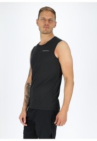 Zwarte mouwloze sportshirt met een gladde textuur en een aansluitend ontwerp. Bevat een klein logo op de borst, gecombineerd met donkere shorts.